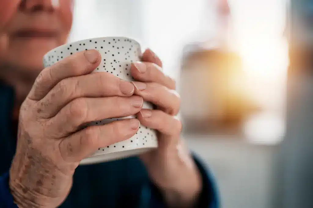 An older woman's hands holding a white spotted mug. Counseling for adults near Tigard, Oregon.