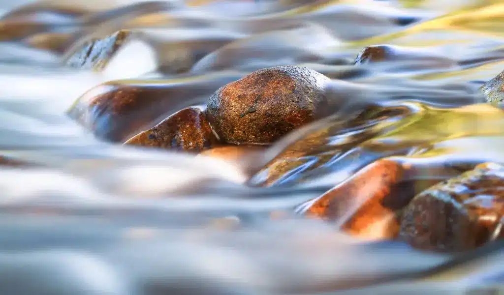 Water flowing smoothly over river stones. Anxiety therapy near Tigard, Oregon.