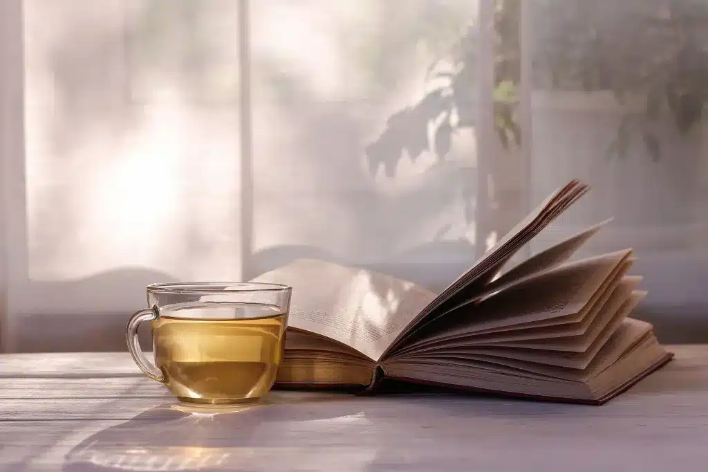A cup of tea beside an open book on a table in soft light. Cognitive Processing Therapy (CPT) near Tigard, Oregon.