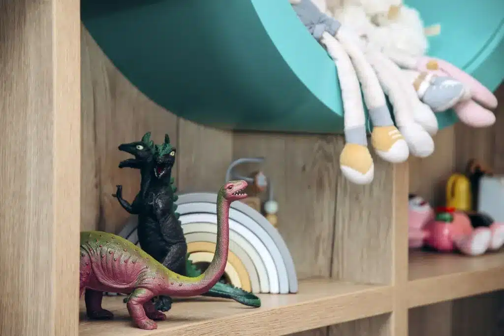 Toys on a wooden shelf, including a dinosaur and a wooden rainbow. Counseling for children, teens, adults and families near Tigard, Oregon.