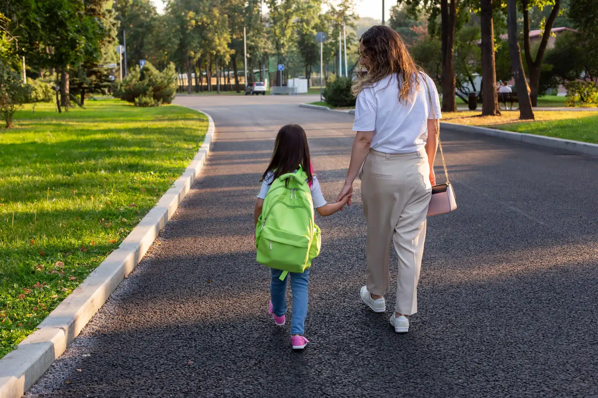 A mother and child walking hand in hand down a path, seen from behind. Signs a child may need a therapist, from a counselor near Tigard, Oregon.